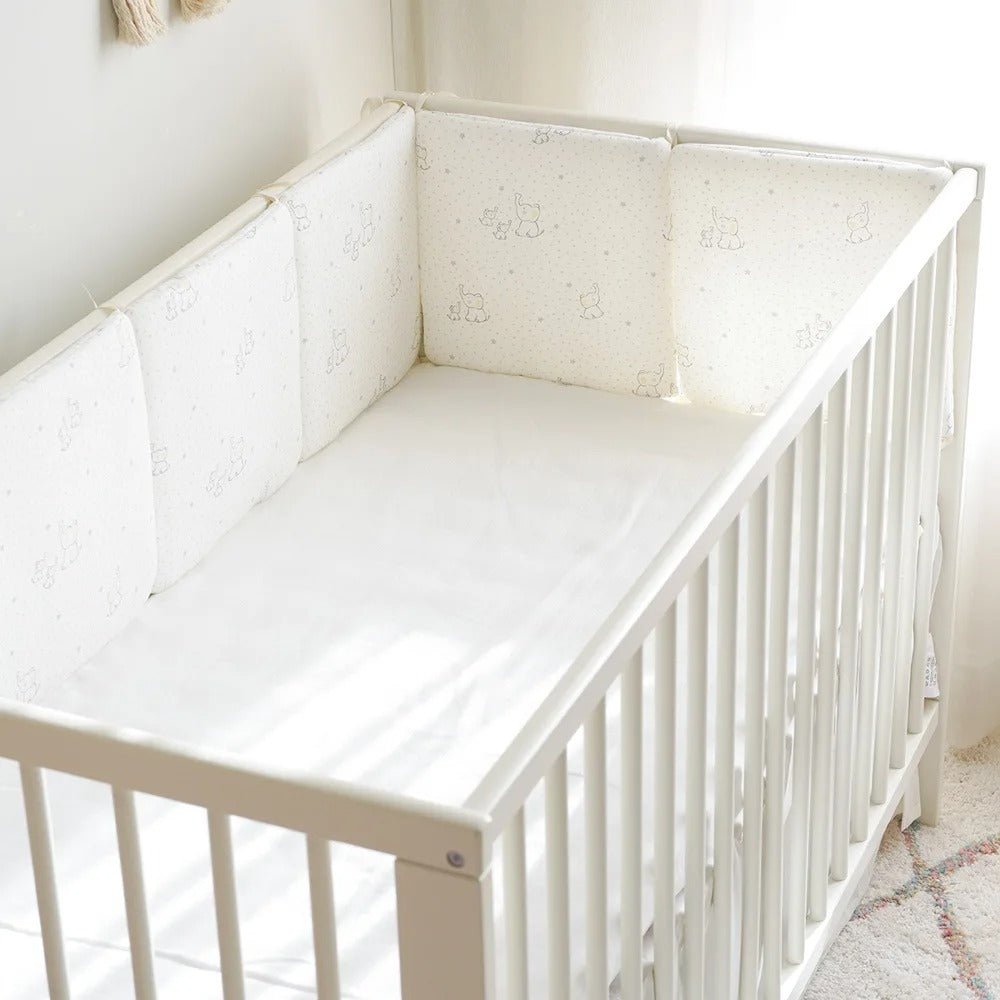 Tour de lit bebe Douceur blanc dans un berceau à côté de la fenêtre