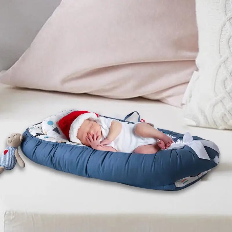 Berceau_Bebe_NidPortableBebe_Voiture-Bleue avec un bébé qui dort avec un chapeau de père noêl