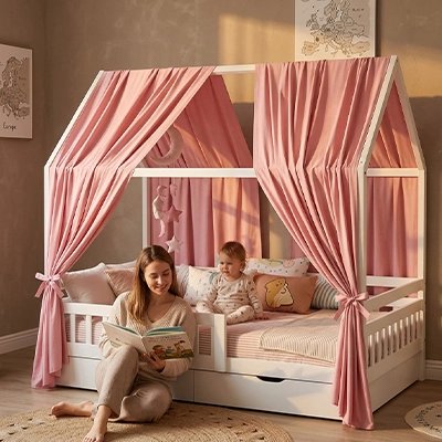 Ciel de lit - cabane | Nuits Magiques Rose avec maman assise contre le lit de bébé et qui lit un livre 