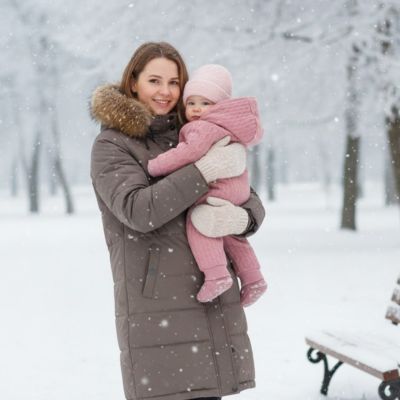 Combinaison pilote bébé | Cocon Douillet TrésorBébé Rose avec maman debout qui tient bébé dans les bras   