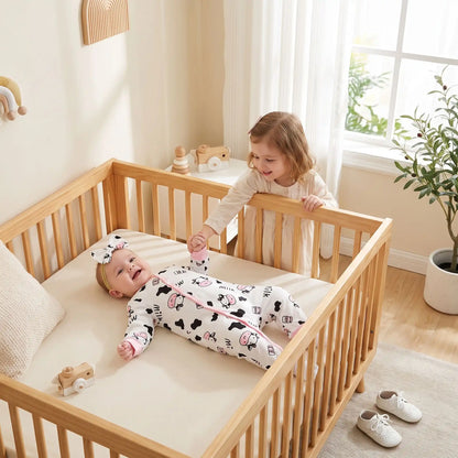 Combinaison pour bebe | Motif Vache Douce avec la fillette qui tient la main de bébé dans le berceau