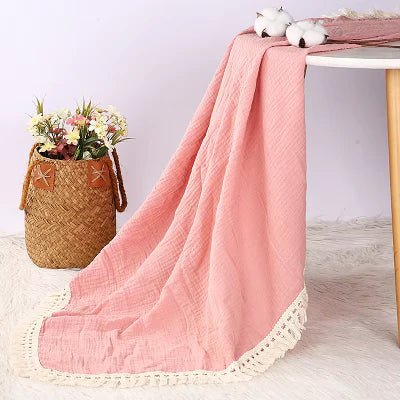 Couverture Bebe - BabyBlanket™ - Rose - qui pend sur le Tapis à côté d'un pot de Fleur