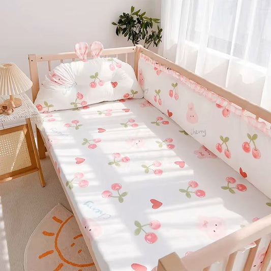 Linge de lit bebe - DouxSommeil- Cerises & Lapins - TrésorBébé dans un berceau avec une table de chevet
