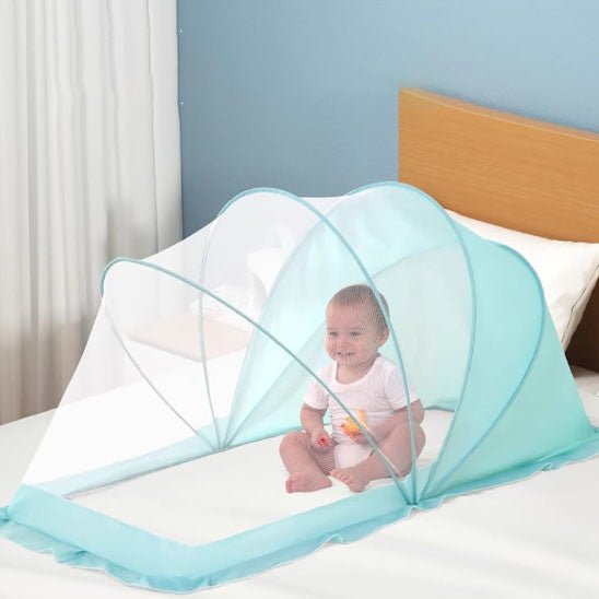 MOUSTIQUAIRE LIT BEBE | PROTECTION ULTRA-RESPIRANTE - TURQUOISE AVEC UN BÉBÉ ASSIS SUR LE LIT ET QUI SOURIT