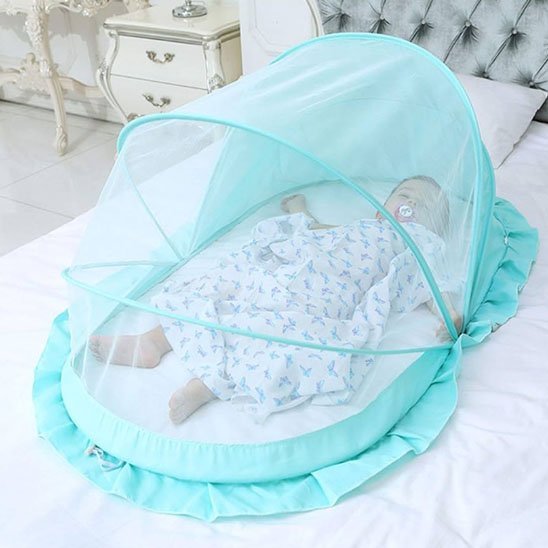 MOUSTIQUAIRE LIT BEBE | PROTECTION ULTRA-RESPIRANTE - TURQUOISE AVEC UN BÉBÉ QUI DORT AVEC UNE TÉTINE DANS LA BOUCHE