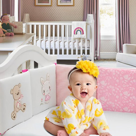 Tour de lit bébé Ours rose avec fillette qui sourit dans un berceau